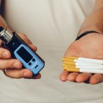 male-holding-cigarettes-and-vape-inhaler-close-up.jpg